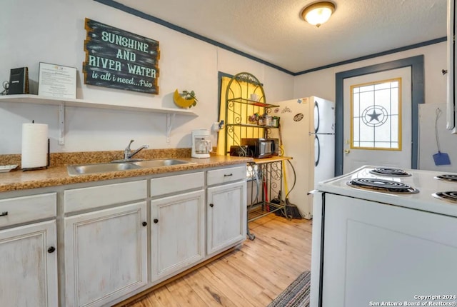 kitchen with white appliances, a sink, white cabinets, open shelves, and light wood finished floors