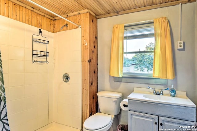 bathroom with tiled shower, wooden ceiling, vanity, and toilet