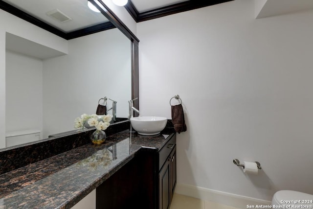 bathroom featuring toilet, ornamental molding, and vanity