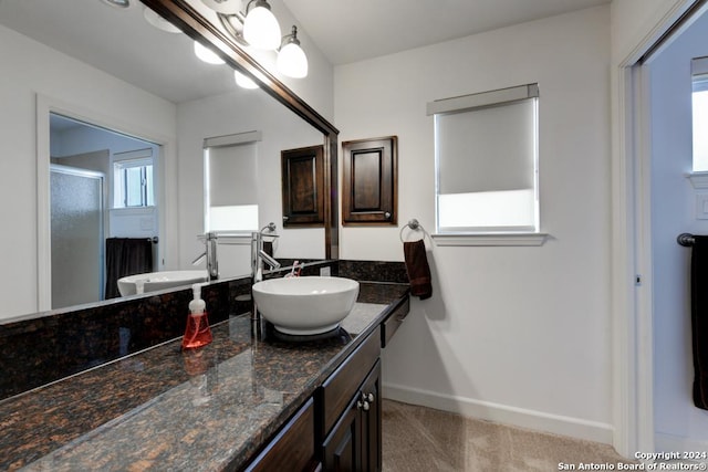 bathroom with a shower with door and vanity