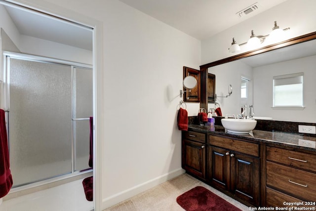 bathroom with vanity and a shower with door