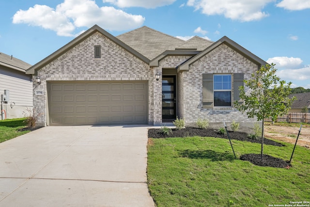 view of front of home featuring a front lawn and a garage