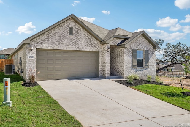 view of front of house featuring a front lawn, a garage, and cooling unit