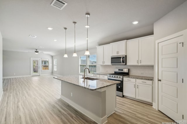 kitchen featuring ceiling fan, a center island with sink, sink, appliances with stainless steel finishes, and white cabinets