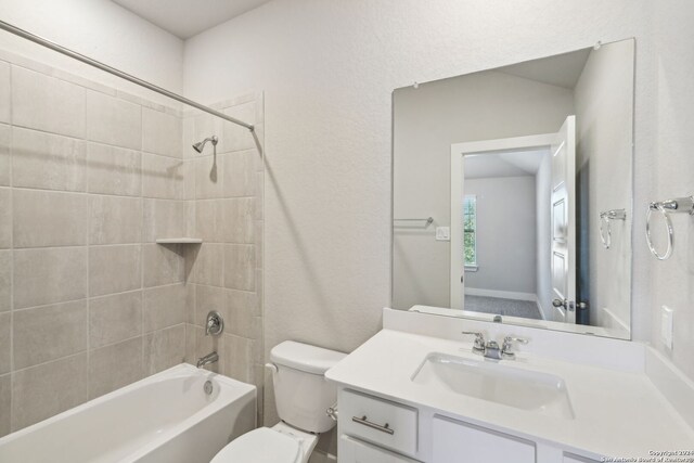 full bathroom with toilet, vanity, and tiled shower / bath