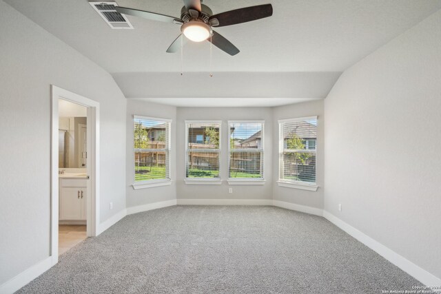 unfurnished room with ceiling fan, light carpet, and vaulted ceiling