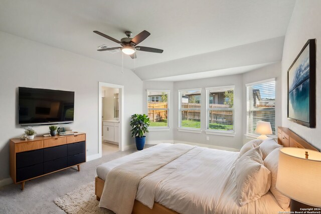 bedroom with light carpet, ceiling fan, lofted ceiling, and ensuite bath