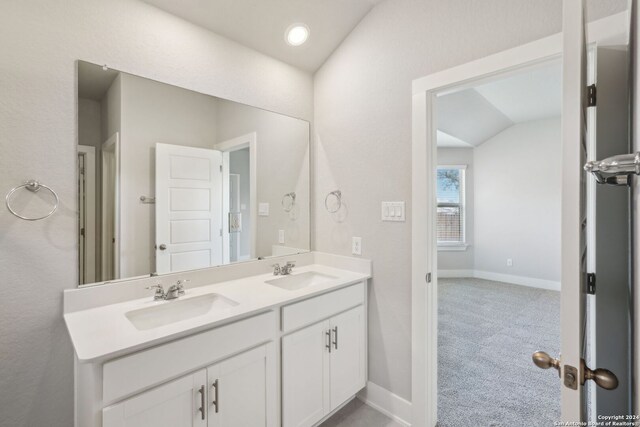 bathroom with vanity and lofted ceiling