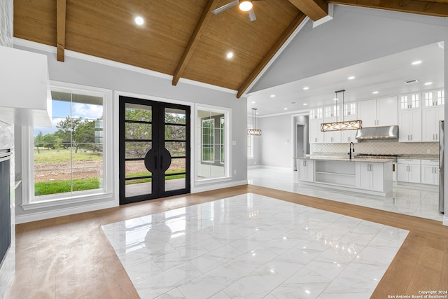 unfurnished living room with french doors, light hardwood / wood-style flooring, beamed ceiling, wooden ceiling, and high vaulted ceiling