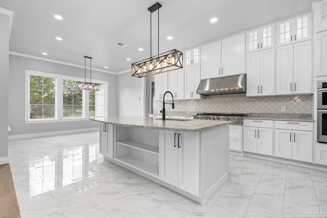 kitchen with white cabinetry, pendant lighting, decorative backsplash, crown molding, and a center island with sink