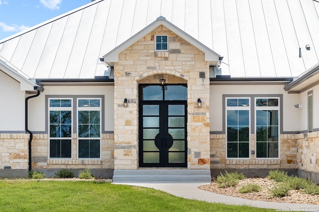 doorway to property featuring french doors and a lawn