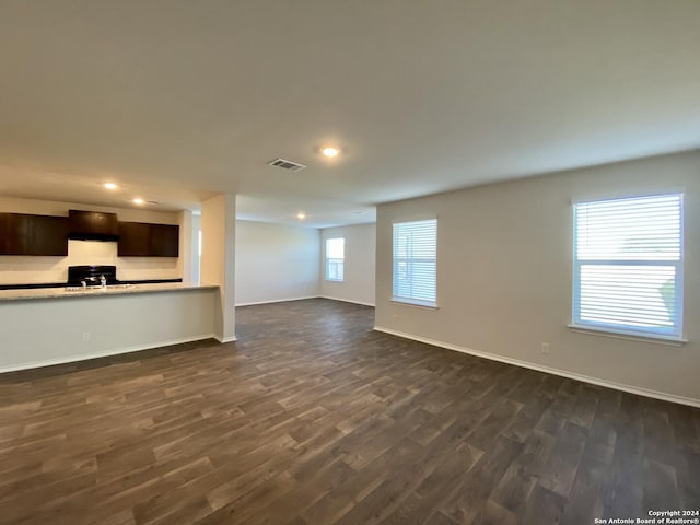 unfurnished living room featuring sink and dark hardwood / wood-style floors