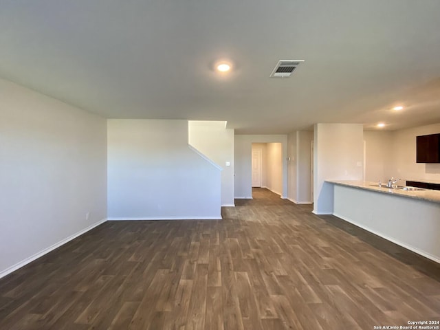 unfurnished living room featuring dark hardwood / wood-style floors and sink