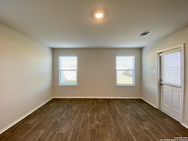 unfurnished room with dark hardwood / wood-style flooring and plenty of natural light