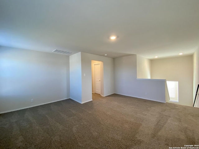 unfurnished room with dark carpet