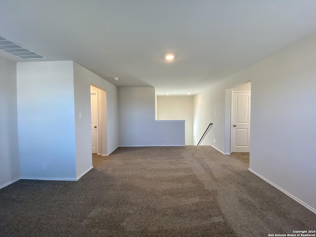 unfurnished room with dark colored carpet