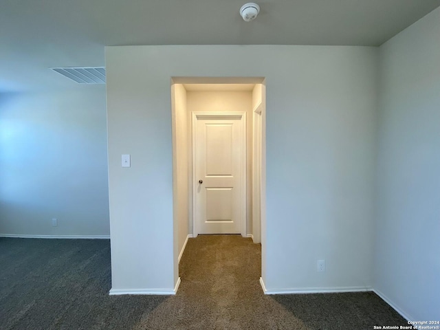 unfurnished room featuring dark carpet