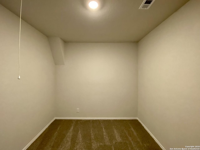 spare room with dark carpet