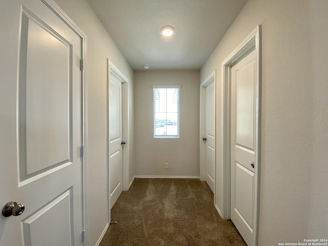 hallway featuring dark colored carpet