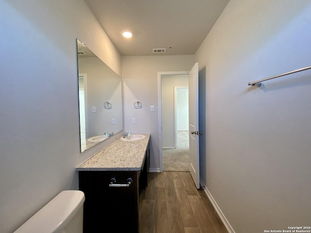 bathroom with hardwood / wood-style flooring, vanity, and toilet