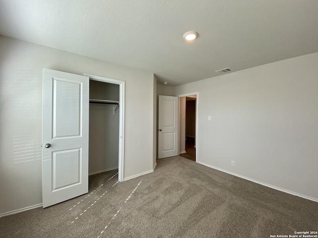 unfurnished bedroom featuring carpet and a closet