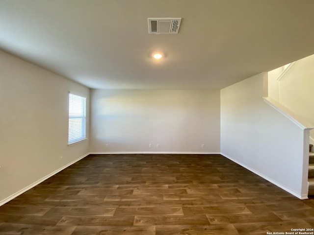 unfurnished room with dark wood-type flooring