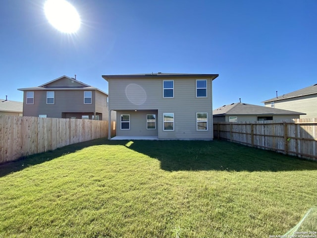 rear view of house featuring a yard and a patio