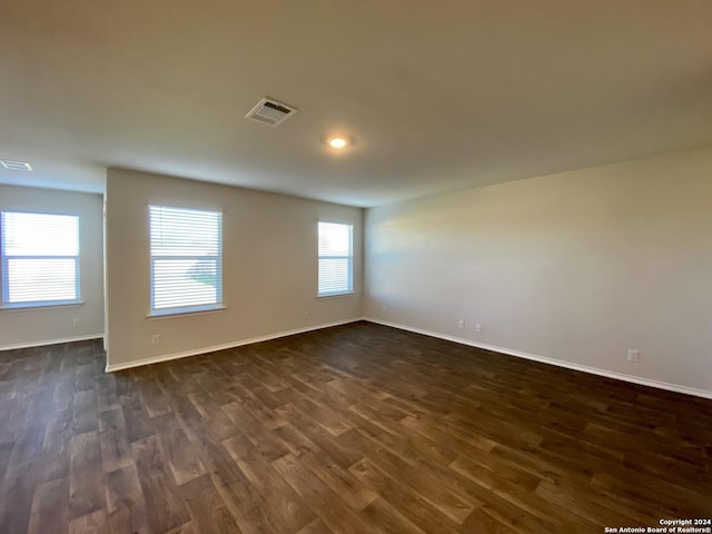 empty room with dark hardwood / wood-style flooring