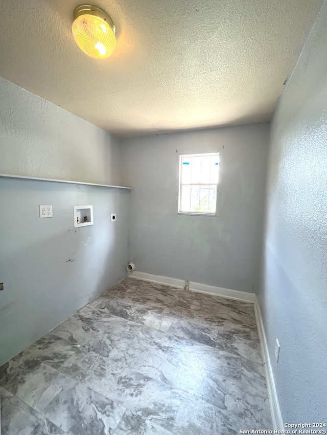 laundry area featuring hookup for a washing machine, a textured ceiling, electric dryer hookup, and tile patterned flooring