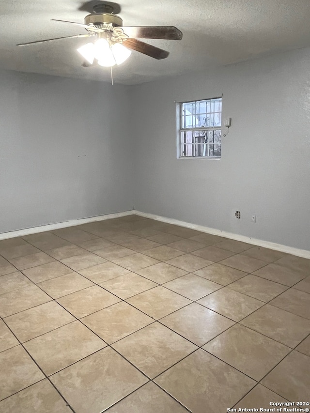 spare room with tile patterned flooring, a textured ceiling, and ceiling fan