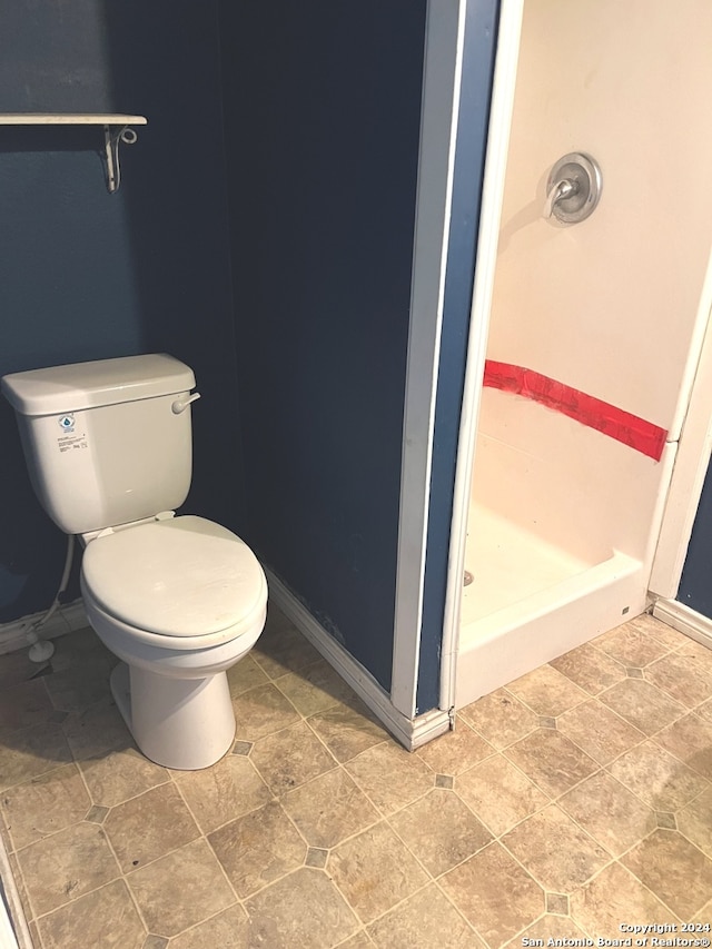 bathroom with tile patterned flooring, a shower, and toilet