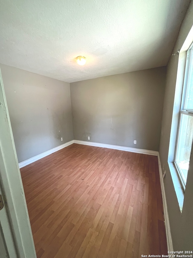 empty room with a textured ceiling and dark wood-type flooring