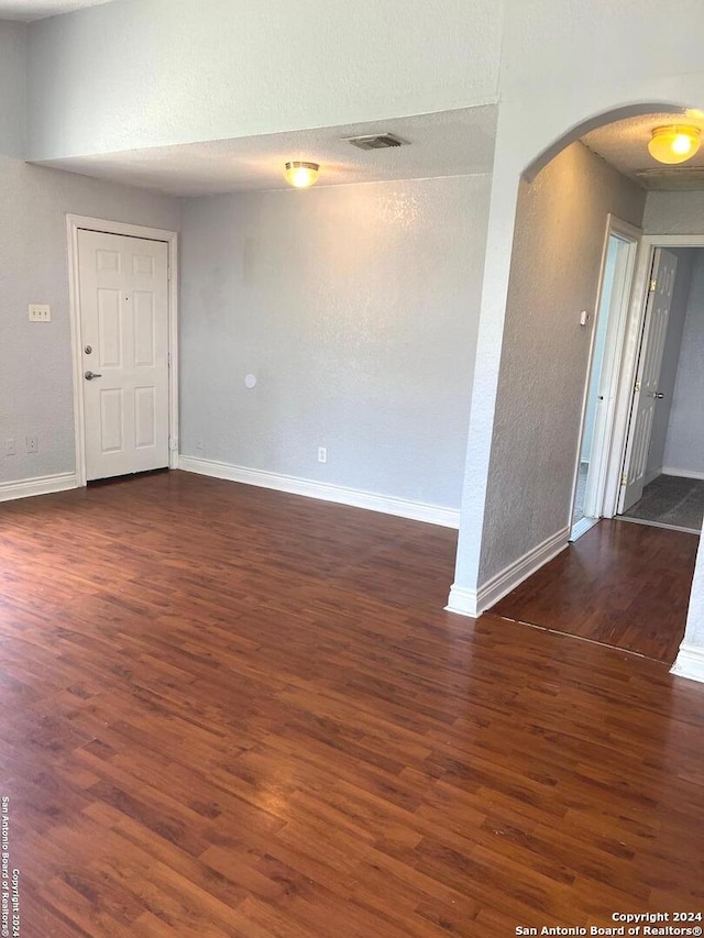 empty room with a textured ceiling and hardwood / wood-style floors