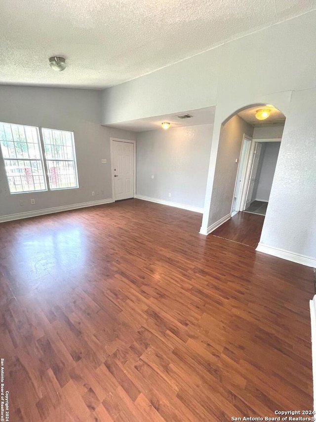 spare room featuring a textured ceiling and hardwood / wood-style floors