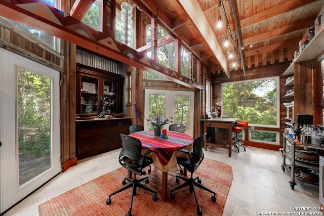 dining area with wooden walls and beam ceiling