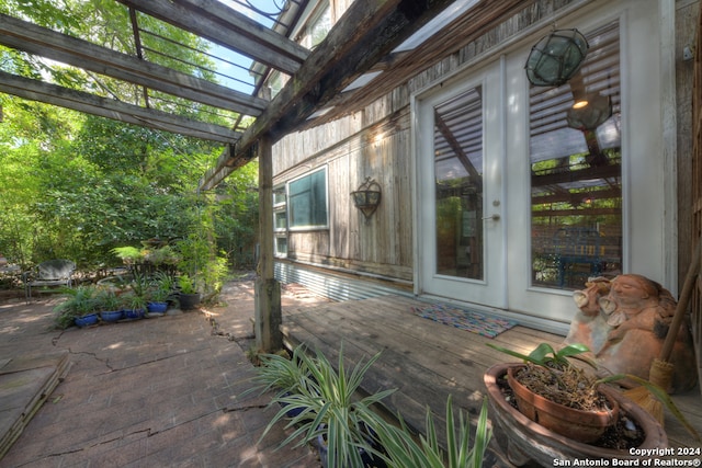 view of patio with french doors, a wooden deck, and a pergola