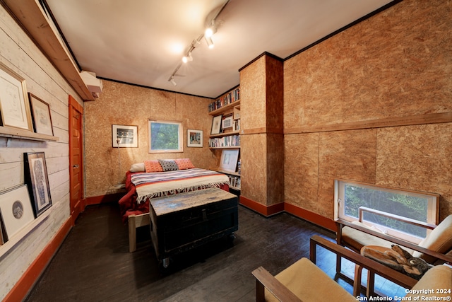 recreation room with dark wood-type flooring, rail lighting, and wooden walls