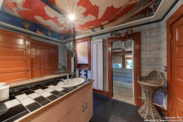 bedroom with multiple windows, wooden walls, and vaulted ceiling