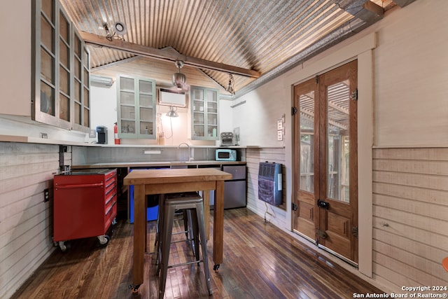 kitchen featuring pendant lighting, wooden walls, heating unit, dark hardwood / wood-style floors, and lofted ceiling with beams