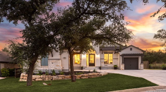 view of front facade featuring a garage and a yard