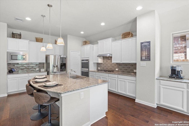 kitchen featuring sink, white cabinetry, hanging light fixtures, a center island with sink, and appliances with stainless steel finishes