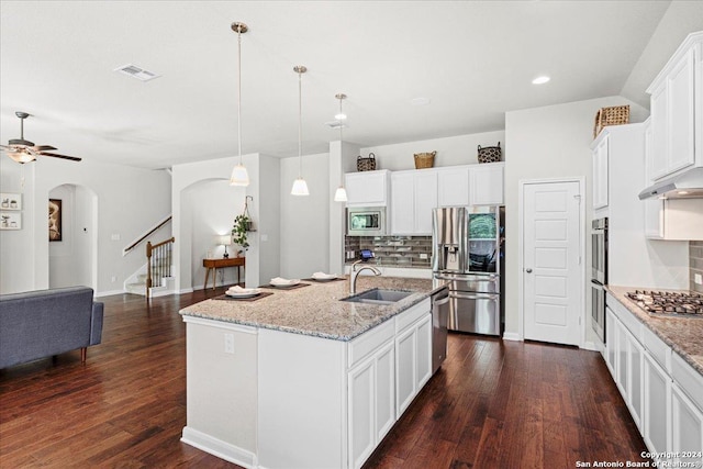 kitchen with appliances with stainless steel finishes, white cabinetry, an island with sink, sink, and decorative backsplash