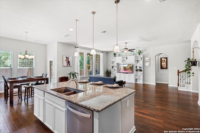 kitchen with white cabinetry, dishwasher, sink, a kitchen island with sink, and light stone counters