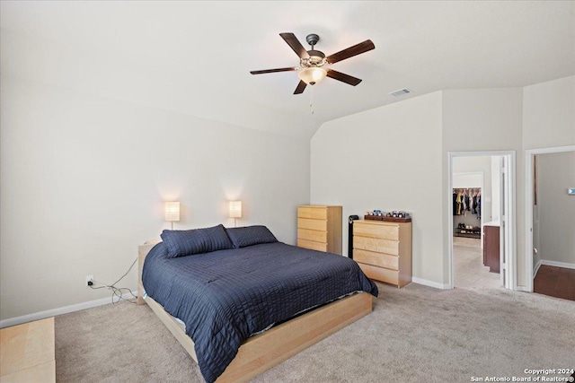 carpeted bedroom with a spacious closet, vaulted ceiling, a closet, and ceiling fan