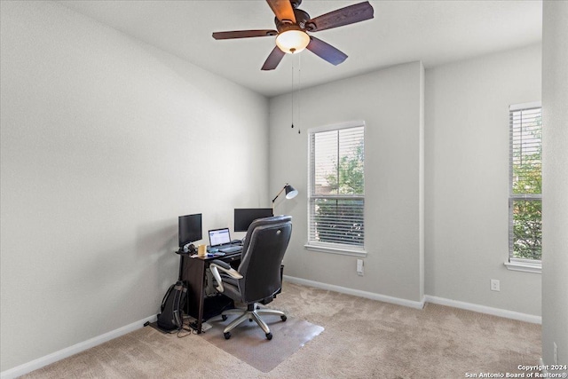 carpeted office space featuring ceiling fan