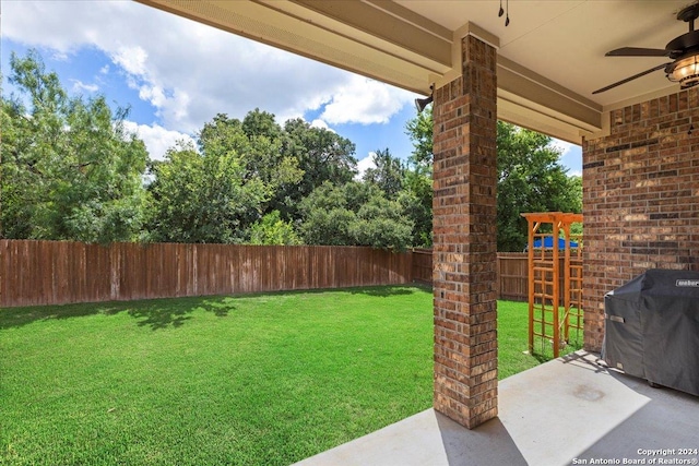 view of yard with ceiling fan and a patio