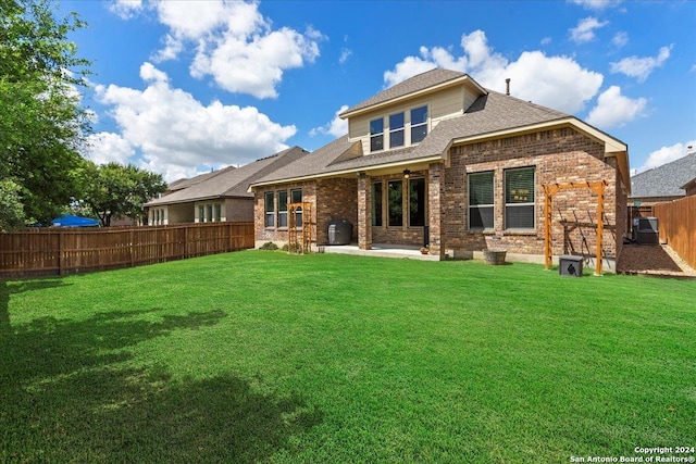 back of property featuring a patio area, a lawn, and central air condition unit