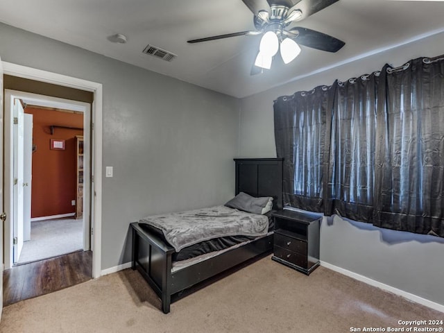 carpeted bedroom with visible vents, ceiling fan, and baseboards