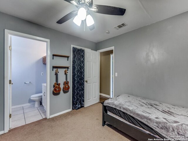 bedroom with ensuite bathroom, ceiling fan, and light colored carpet