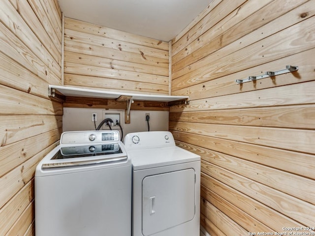 laundry room with laundry area, independent washer and dryer, and wooden walls